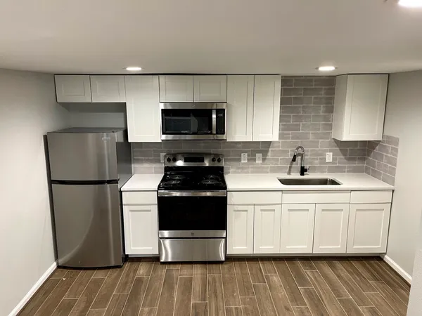 a kitchen with a refrigerator stove and white cabinets