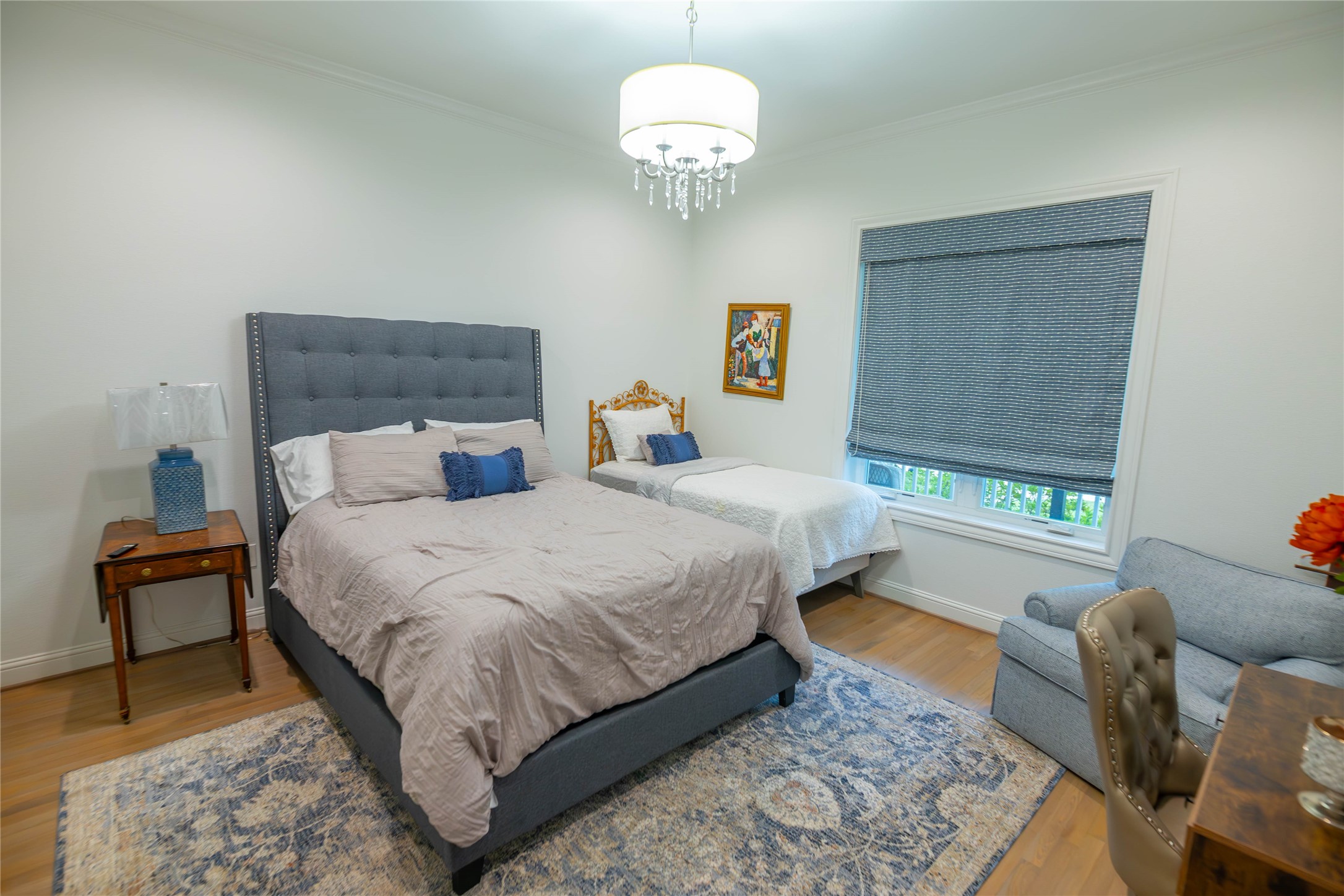 10614 Moonlight Drive Houston, TX 77096 - Photo 22 of 27 a bedroom with a bed and a chandelier