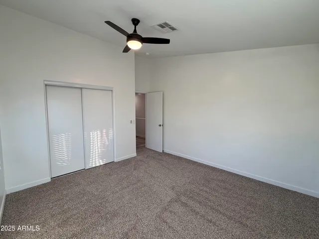 an empty room with a ceiling fan and a window