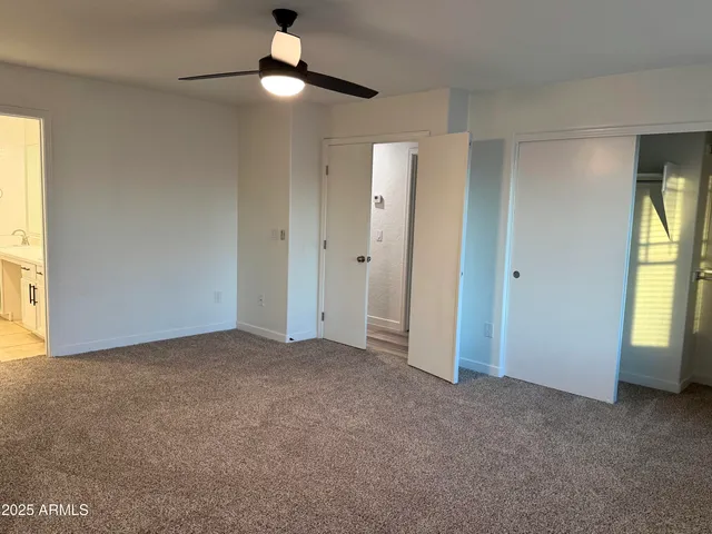 a view of an empty room with a window and a kitchen