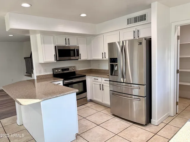 a kitchen with appliances a sink and a refrigerator