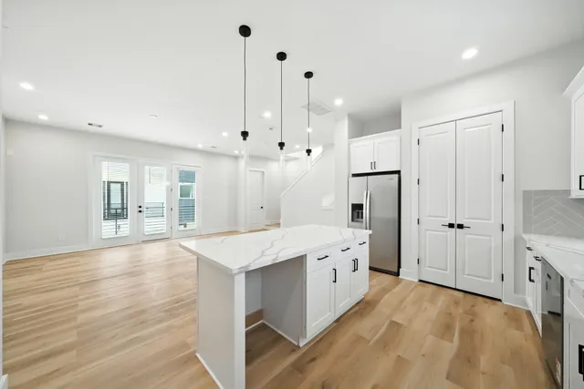 a large kitchen with stainless steel appliances granite countertop a stove and a sink