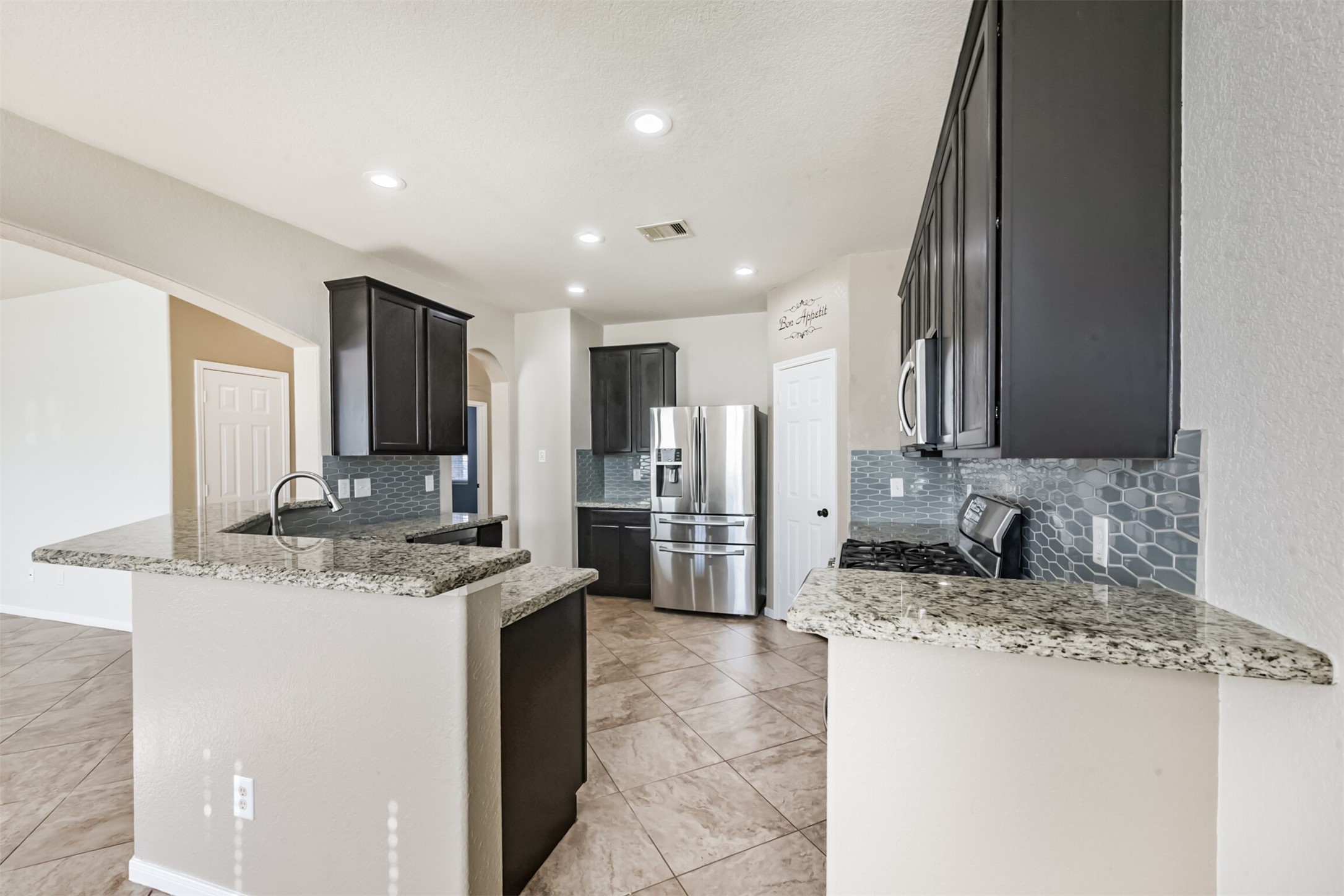 1305 Pinto Pass Alvin, TX 77511 - Photo 11 of 40 a kitchen with stainless steel appliances granite countertop a sink stove and refrigerator