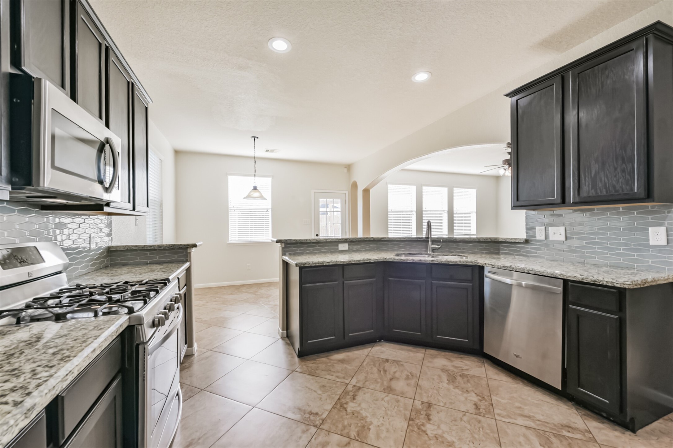 1305 Pinto Pass Alvin, TX 77511 - Photo 12 of 40 a large kitchen with stainless steel appliances granite countertop a stove and a sink
