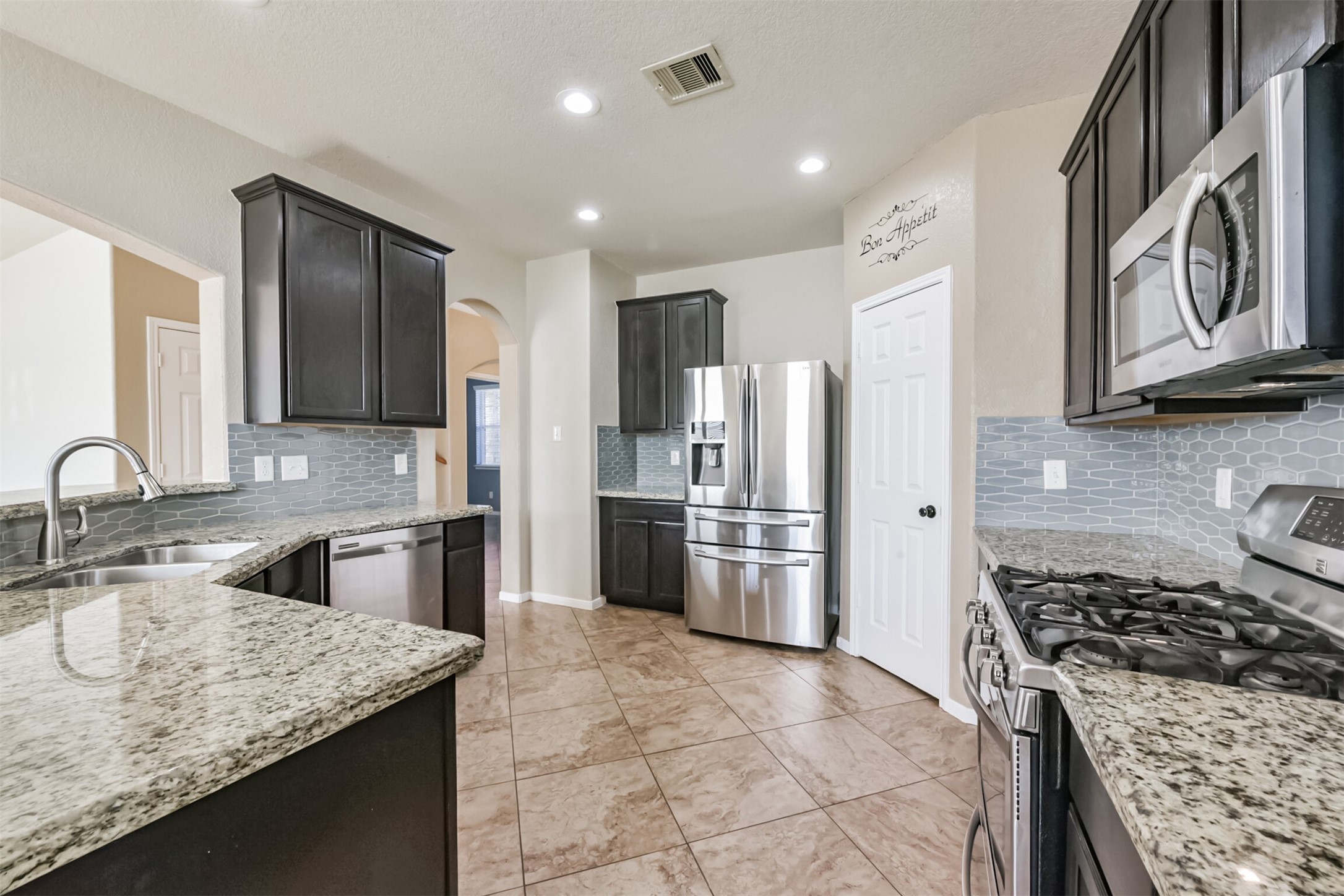 1305 Pinto Pass Alvin, TX 77511 - Photo 13 of 40 a kitchen with stainless steel appliances granite countertop a sink stove and refrigerator