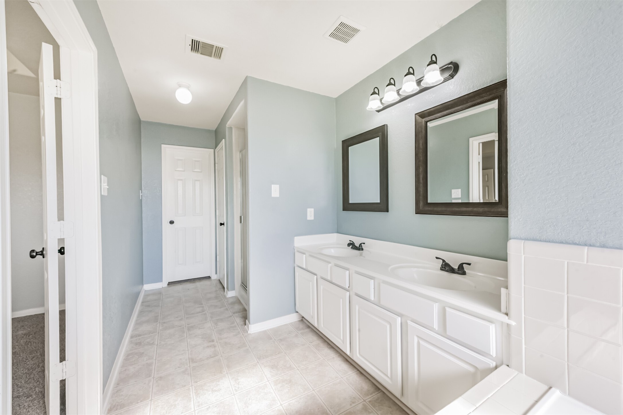 1305 Pinto Pass Alvin, TX 77511 - Photo 26 of 40 a spacious bathroom with a double vanity sink mirror and bathtub