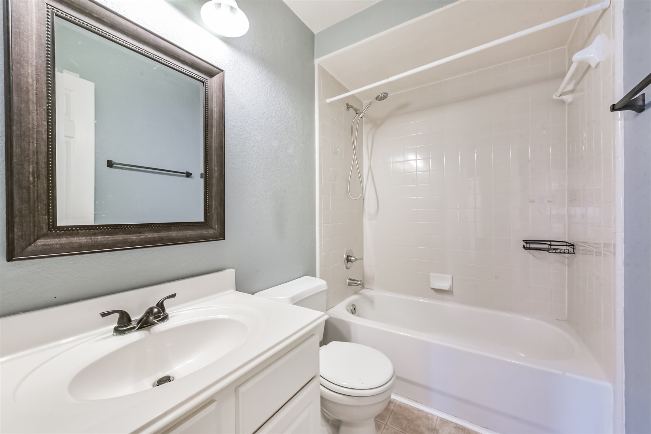 1305 Pinto Pass Alvin, TX 77511 - Photo 34 of 40 a bathroom with a bathtub shower sink vanity mirror and toilet