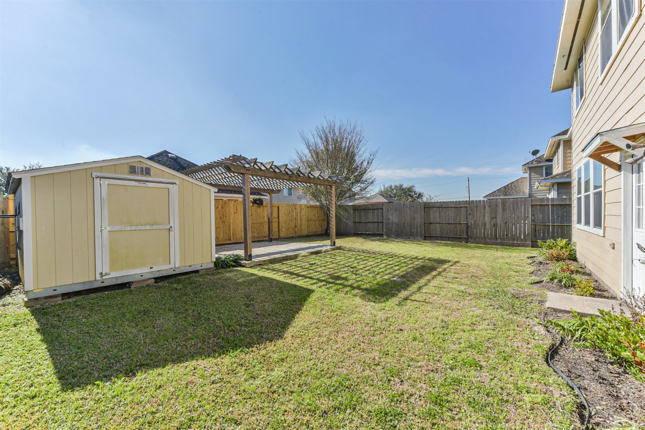 1305 Pinto Pass Alvin, TX 77511 - Photo 36 of 40 a view of a white house next to a yard with wooden fence