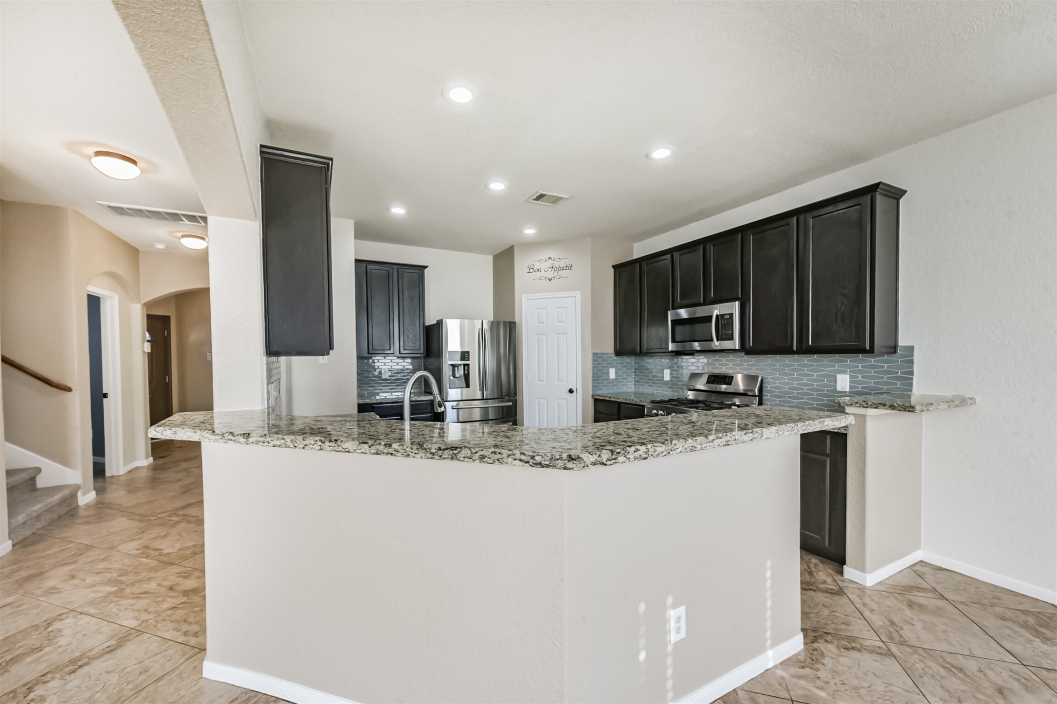 1305 Pinto Pass Alvin, TX 77511 - Photo 10 of 40 a kitchen with stainless steel appliances granite countertop a sink and a refrigerator