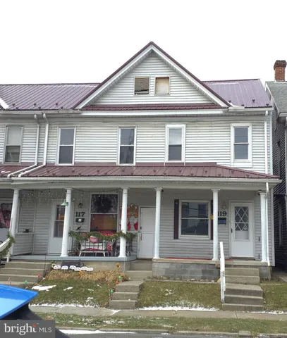 a front view of a house with swimming pool and chairs