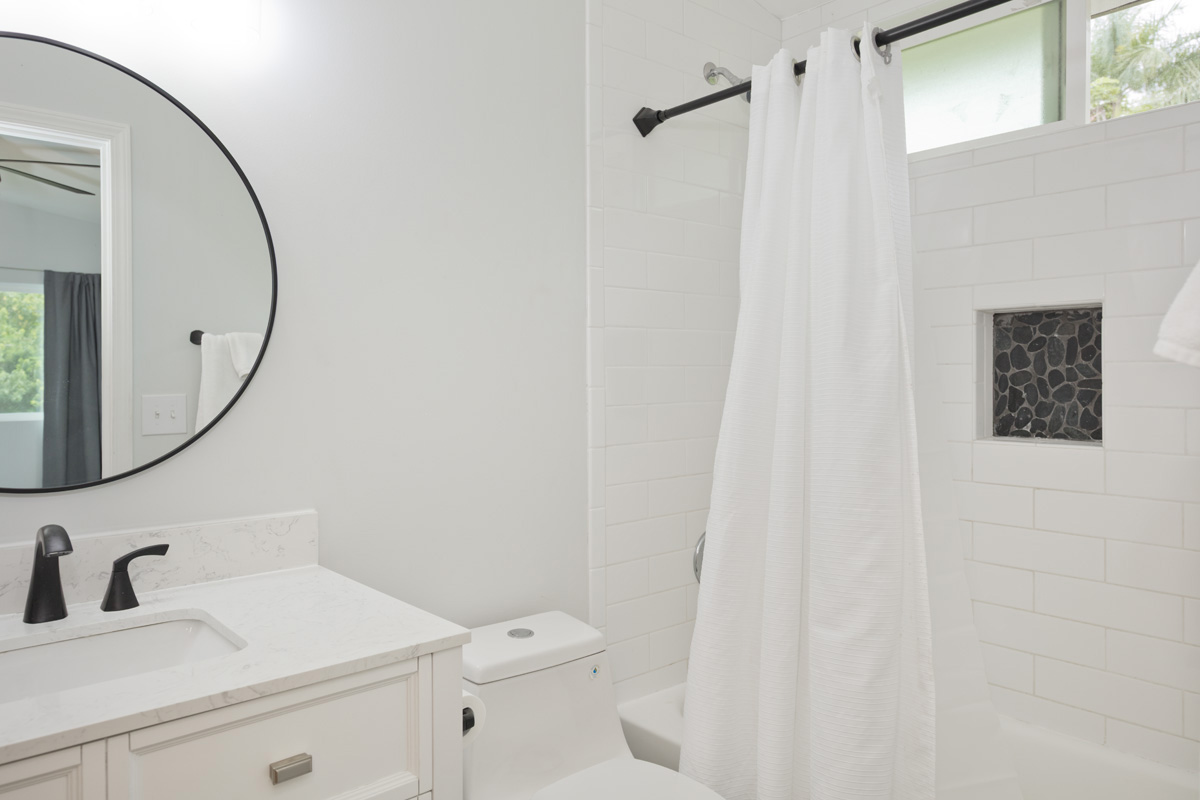 87-2451 Hawaiʻi Belt Road Captain Cook, HI 96704 - Photo 13 of 30 a bathroom with a sink a toilet and a mirror