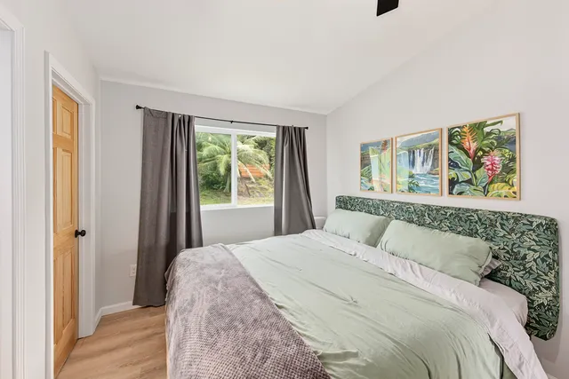 a bedroom with a bed and a painting on the wall