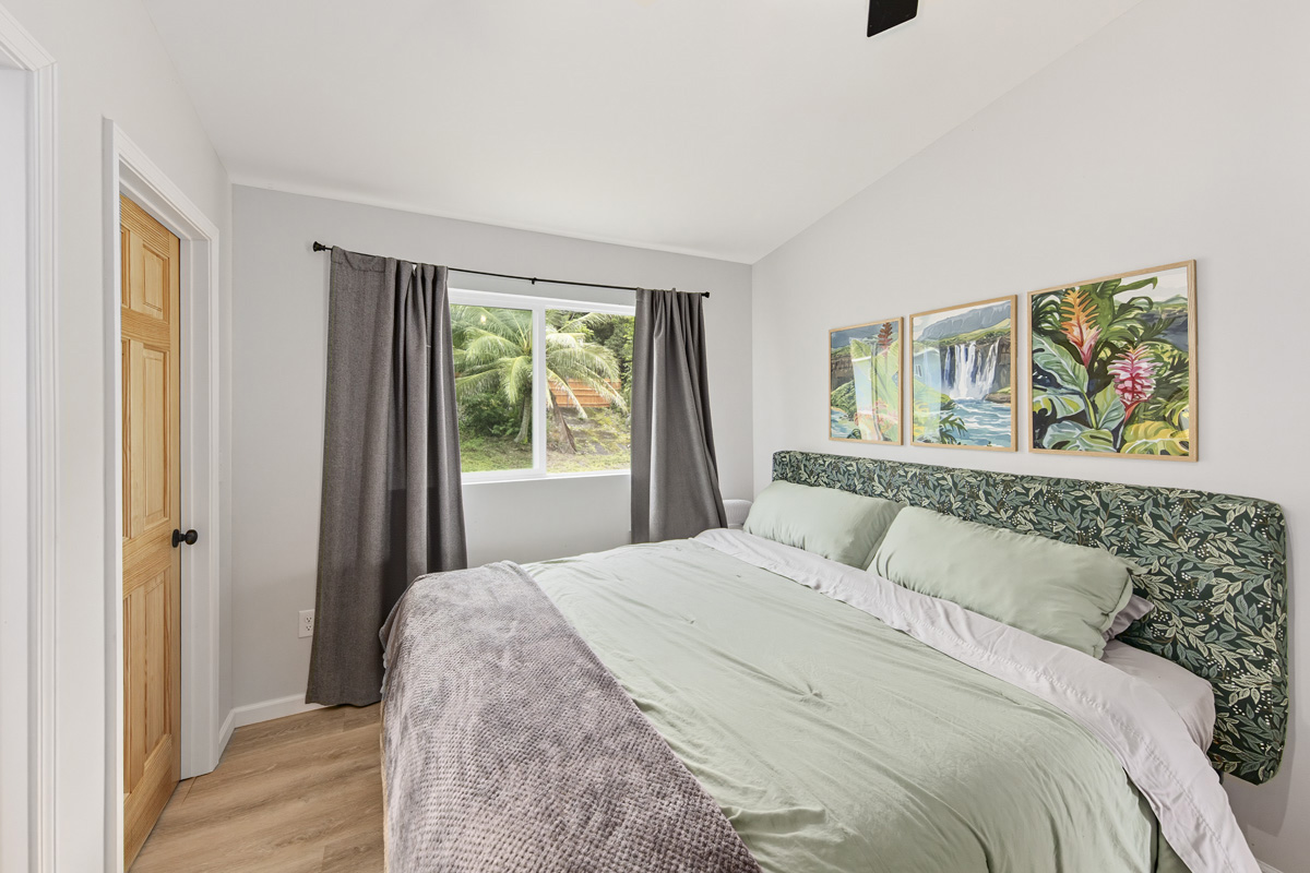 87-2451 Hawaiʻi Belt Road Captain Cook, HI 96704 - Photo 15 of 30 a bedroom with a bed and a painting on the wall