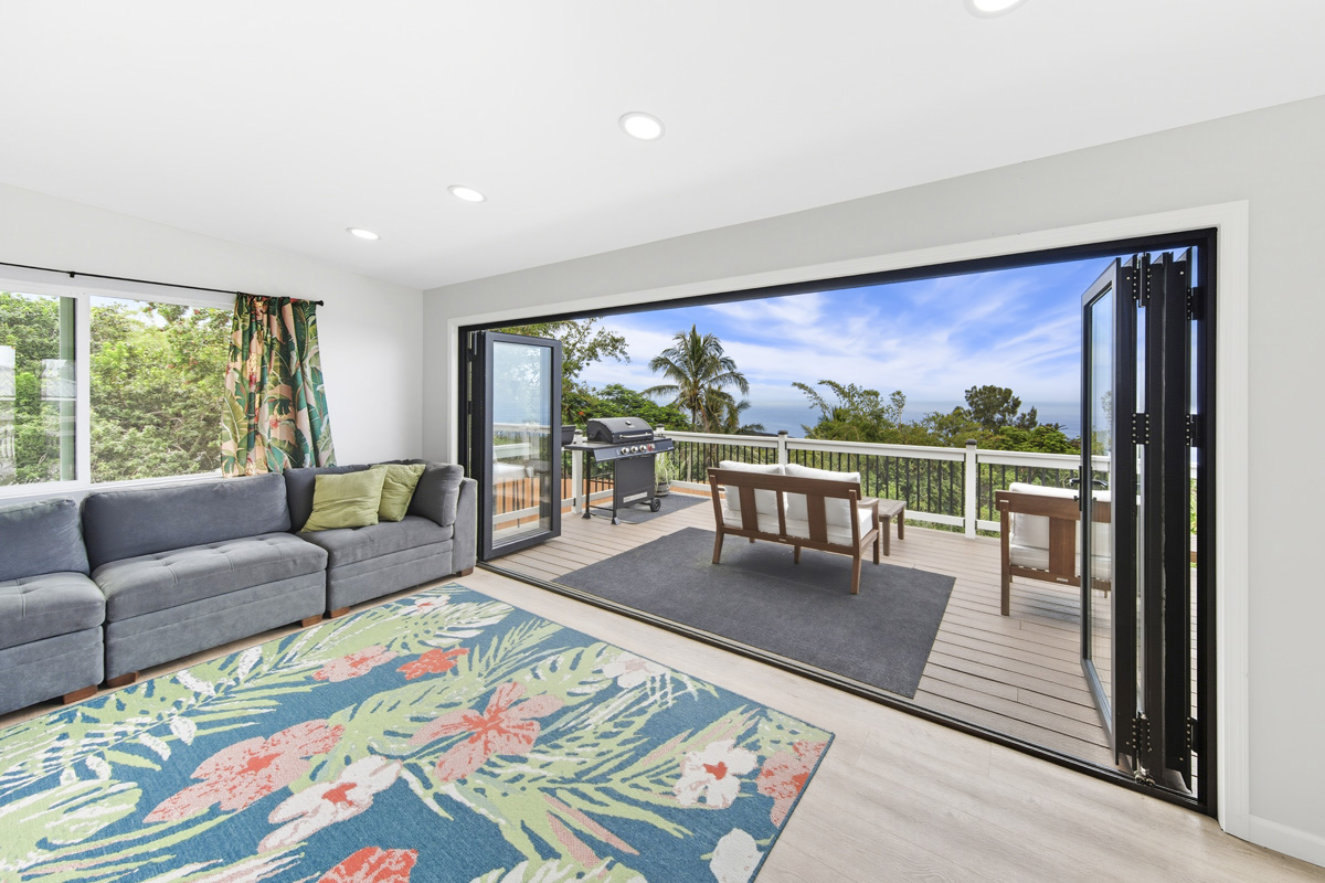 87-2451 Hawaiʻi Belt Road Captain Cook, HI 96704 - Photo 2 of 30 a living room with furniture floor to ceiling window wooden floor and floor to ceiling windows