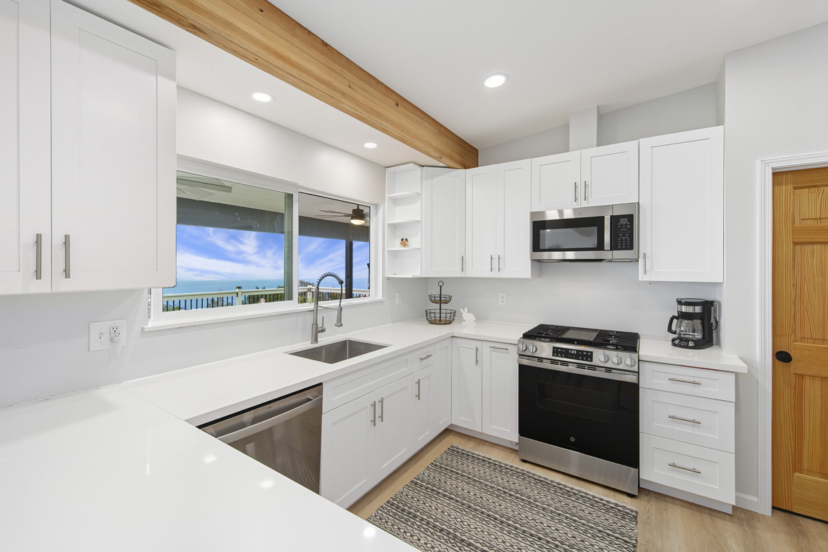 87-2451 Hawaiʻi Belt Road Captain Cook, HI 96704 - Photo 6 of 30 a kitchen with stainless steel appliances a sink stove and cabinets