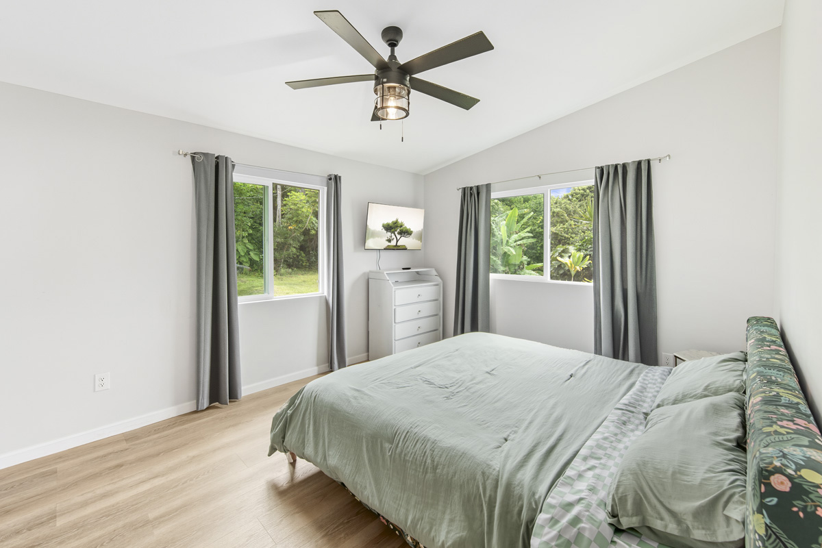 87-2451 Hawaiʻi Belt Road Captain Cook, HI 96704 - Photo 10 of 30 a bedroom with a bed and a large window