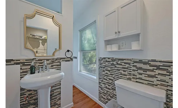 a bathroom with a sink a toilet and mirror