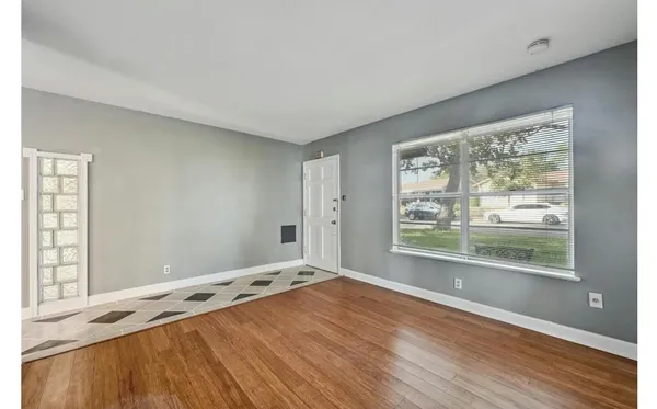 a view of a room with wooden floor and white walls
