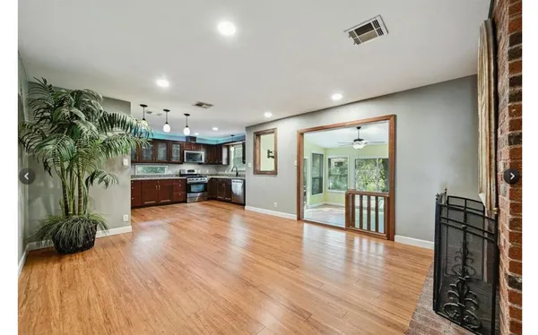 a view of a living room and kitchen with furniture wooden floor and windows