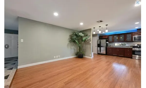 a view of kitchen with sink and refrigerator