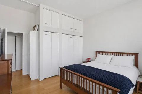 a bedroom with a bed and cabinets