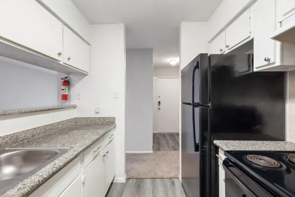 a kitchen with granite countertop a refrigerator and a sink