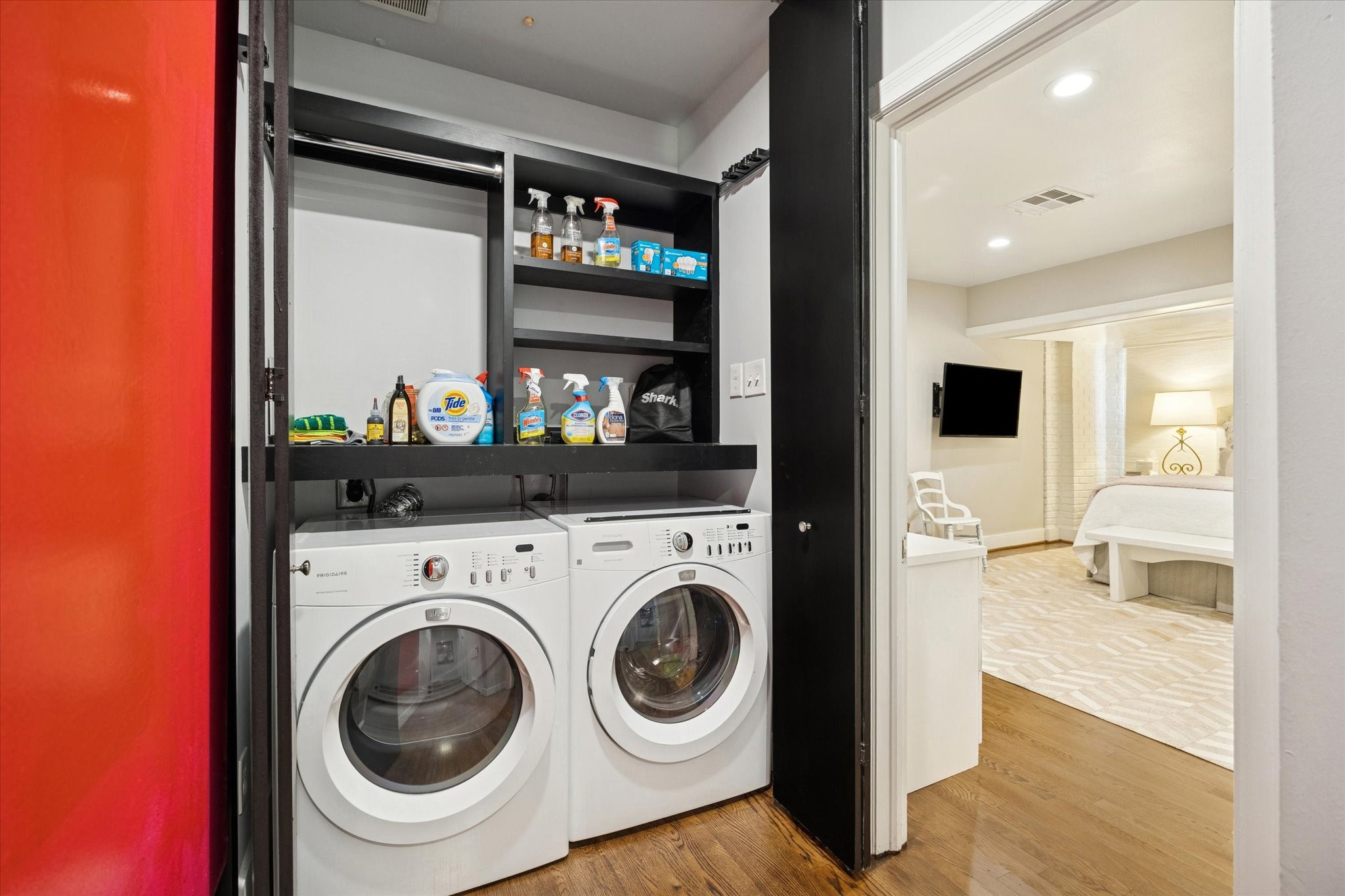 2109 Colquitt Street Houston, TX 77098 - Photo 24 of 28 A dedicated laundry area features front-loading washer and dryer with built-in shelving for organized storage.