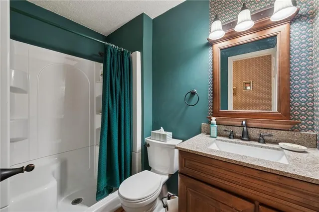 a bathroom with a sink a toilet and shower