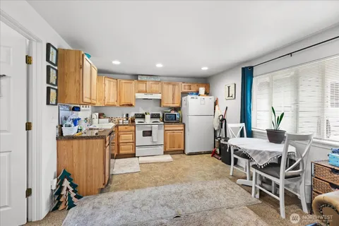 a kitchen with white cabinets and refrigerator