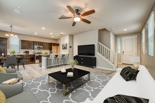 a living room with furniture kitchen view and a flat screen tv