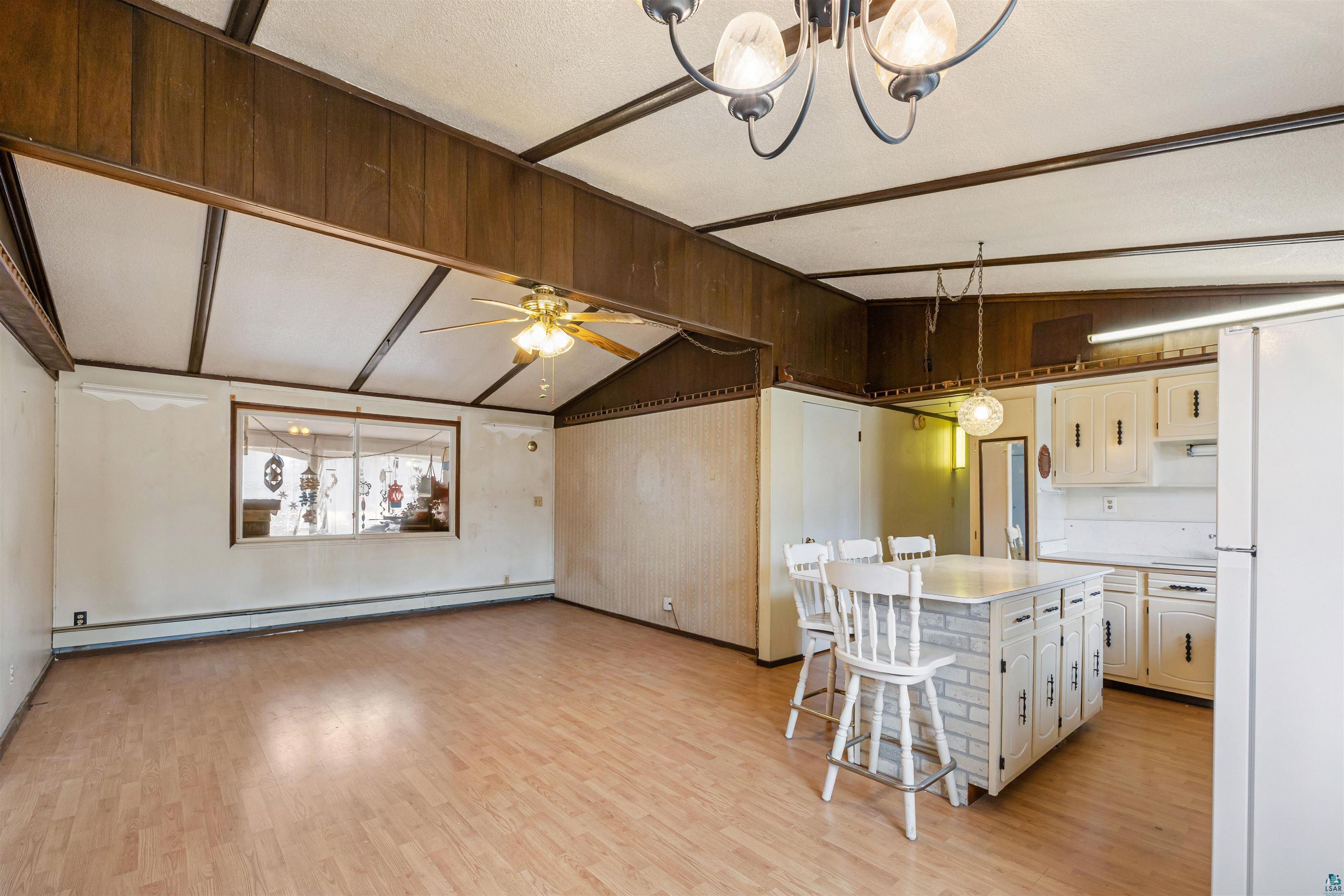 11574 Town Line Road Hibbing, MN 55746 - Photo 5 of 41 Open-concept living space featuring wood-finish flooring, vaulted ceilings with exposed wood beams, and a ceiling fan