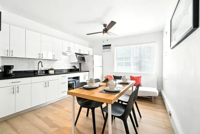 a kitchen with a dining table chairs and white cabinets