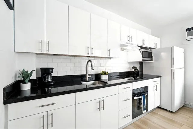 a kitchen with appliances a sink and cabinets