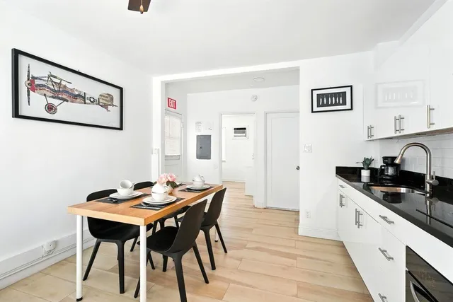 a kitchen with stainless steel appliances kitchen island a table and chairs in it