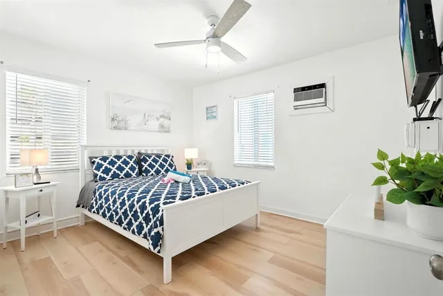 a bed sitting in a bedroom next to a window with a flat screen tv