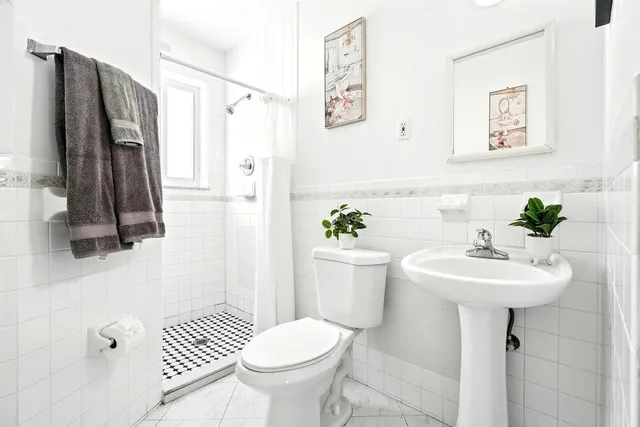 a bathroom with a sink toilet and a mirror