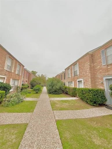 2211 South Kirkwood Road, Unit 28 Houston, TX 77077 - Photo 6 of 9 a view of a big house with a big yard and large trees