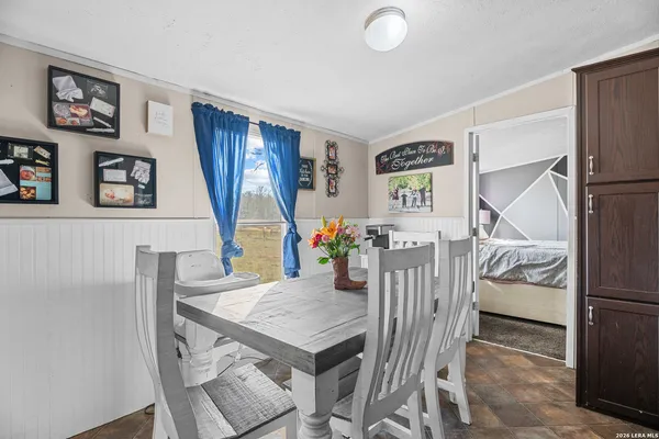 a bedroom with a bed and a flat tv screen on dresser