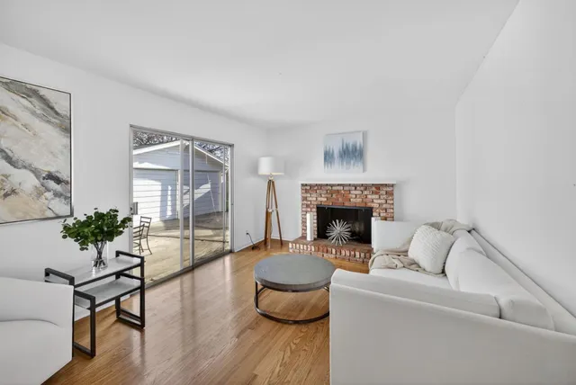 a living room with furniture fireplace and potted plants