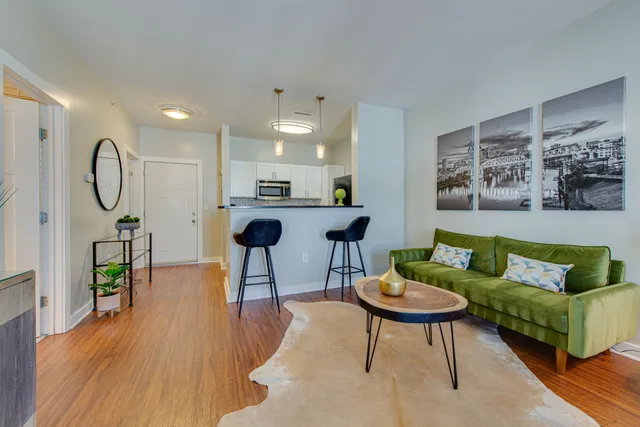 a living room with furniture a rug and a table
