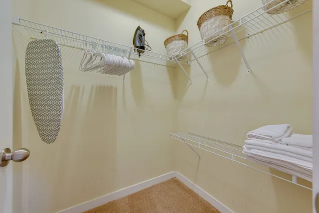 a spacious bedroom with a bed a table and a chandelier