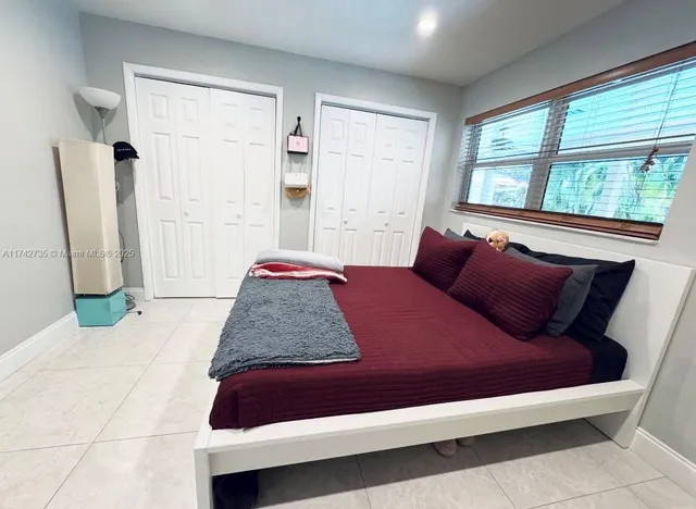 a bed sitting in a bedroom next to a window