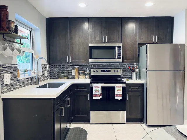 a kitchen with stainless steel appliances granite countertop a refrigerator stove a sink and dishwasher