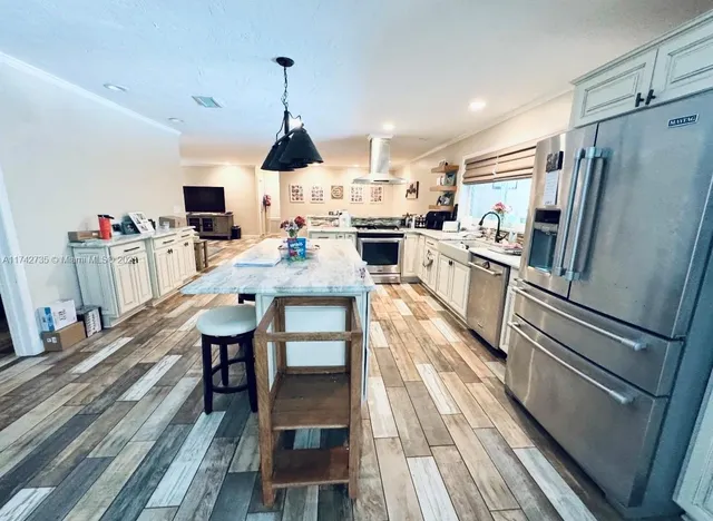 a living room with stainless steel appliances kitchen island granite countertop furniture and a kitchen view