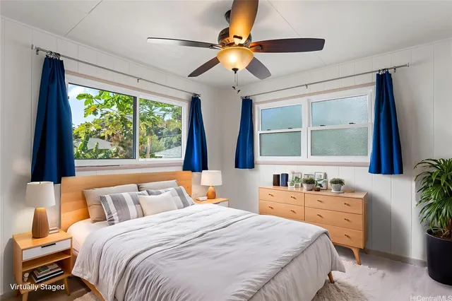 a bedroom with a bed a large window and potted plant