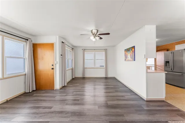 a view of a kitchen with a refrigerator a ceiling fan and wooden floor