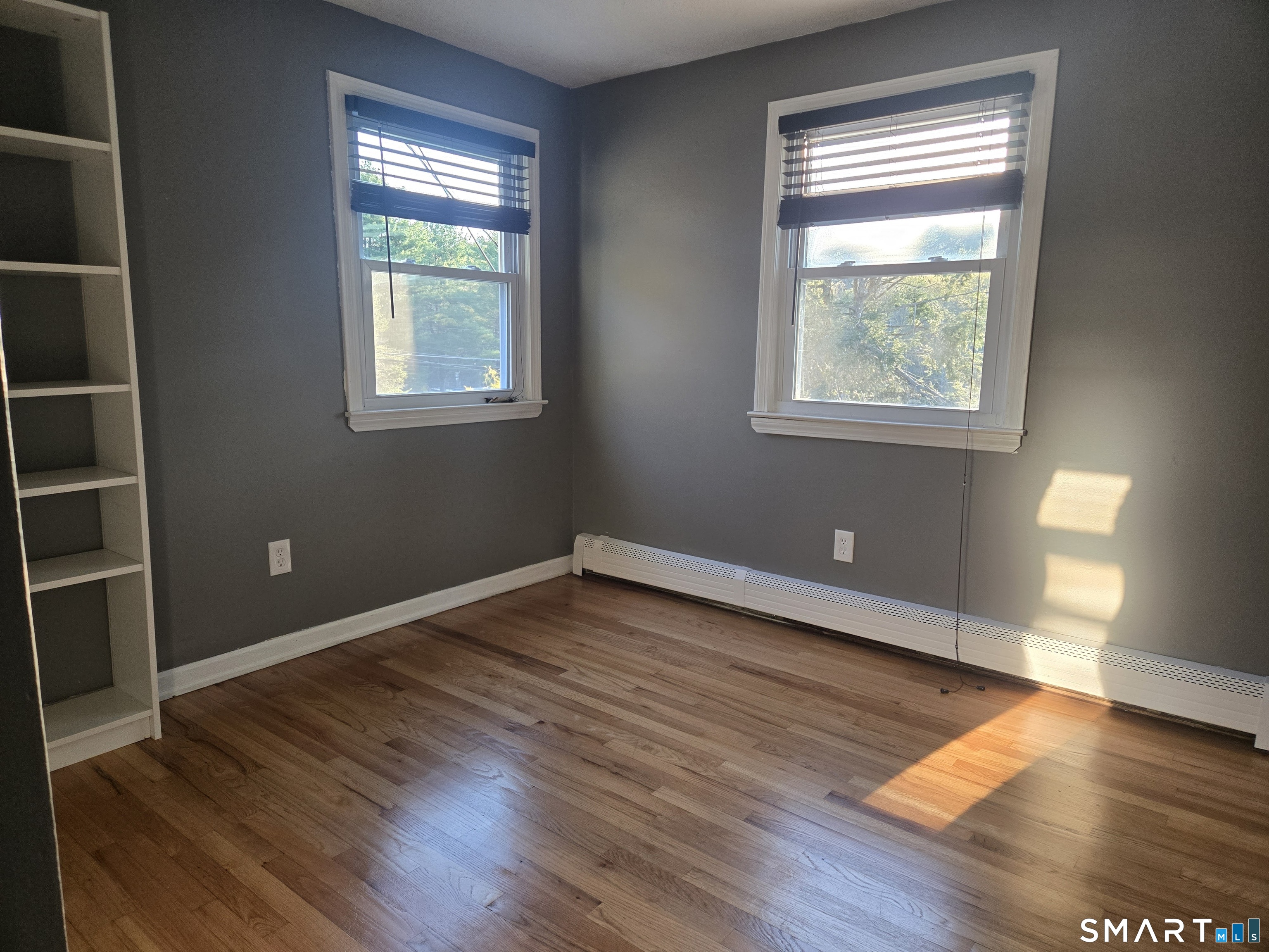 1004 Hickory Hill Road Thomaston, CT 06787 - Photo 17 of 23 an empty room with wooden floor and windows