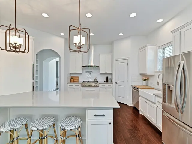 a kitchen with stainless steel appliances a refrigerator a sink cabinets a stove and a center island