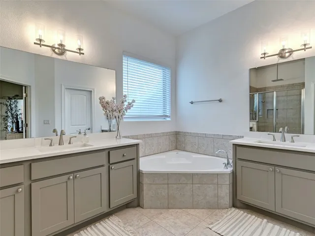 a bathroom with a tub sink and mirror