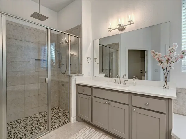 a bathroom with a shower sink and mirror